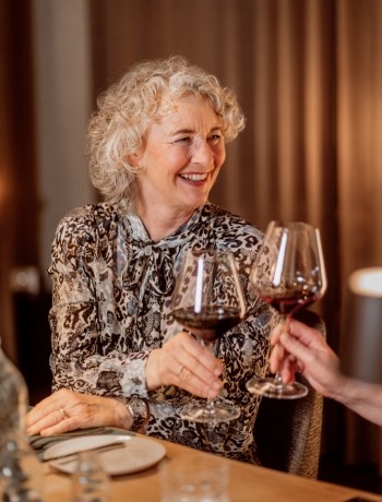 Frau genießt ein Glas Rotwein in gemütlicher Atmosphäre